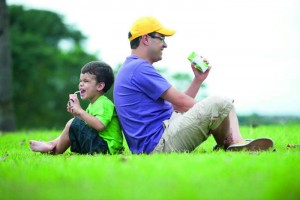 Man and boy sitting in the grass